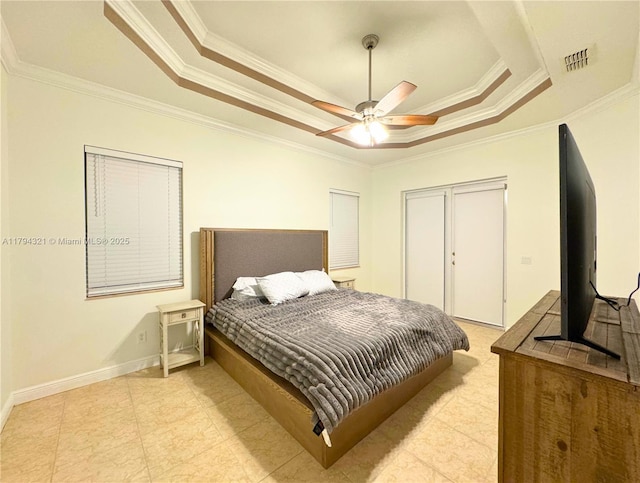 bedroom with visible vents, ornamental molding, a raised ceiling, and a closet