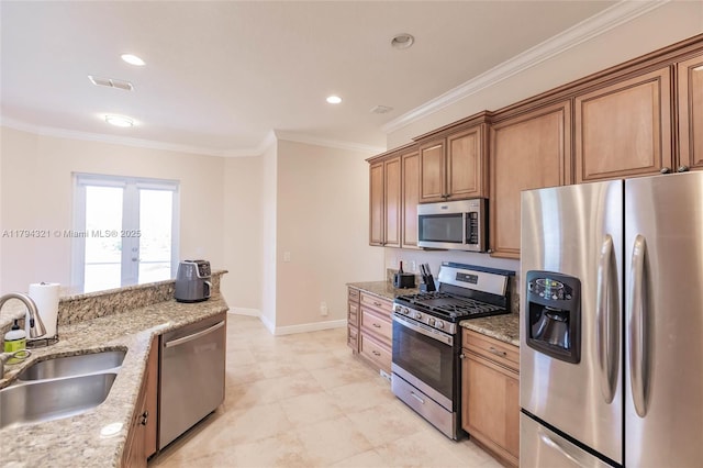 2041 SW Imperial St, Port St Lucie, FL 34987 - kitchen with stainless steel appliances, a sink, ornamental molding, light stone countertops, and brown cabinets