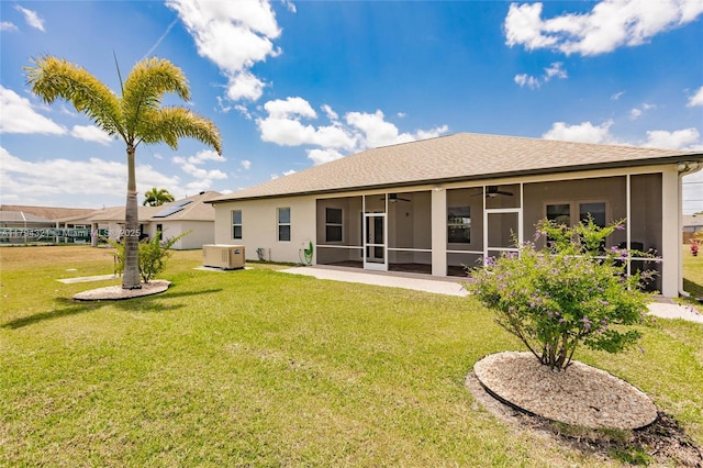 2041 SW Imperial St, Port St Lucie, FL 34987 - back of house featuring a ceiling fan, a sunroom, a yard, stucco siding, and roof with shingles