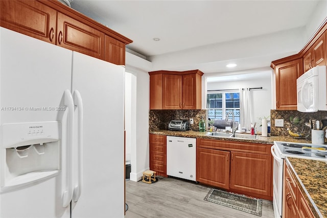kitchen featuring white appliances, light wood-type flooring, recessed lighting, a sink, and backsplash
