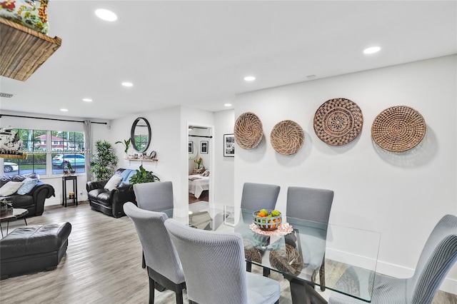 dining area featuring baseboards, recessed lighting, and wood finished floors