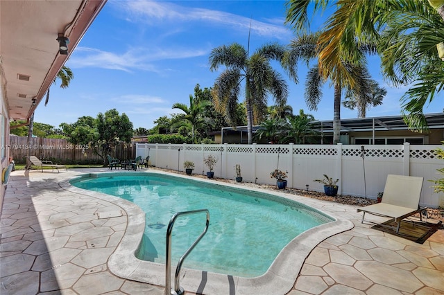view of swimming pool with a fenced in pool, a fenced backyard, and a patio area