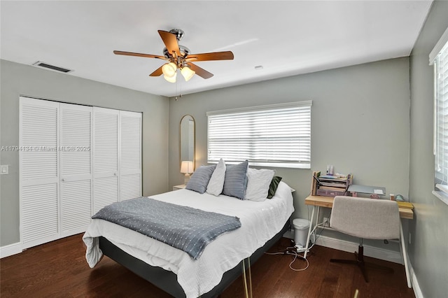 bedroom with visible vents, baseboards, wood finished floors, and a closet