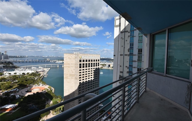 balcony with a water view and a view of city