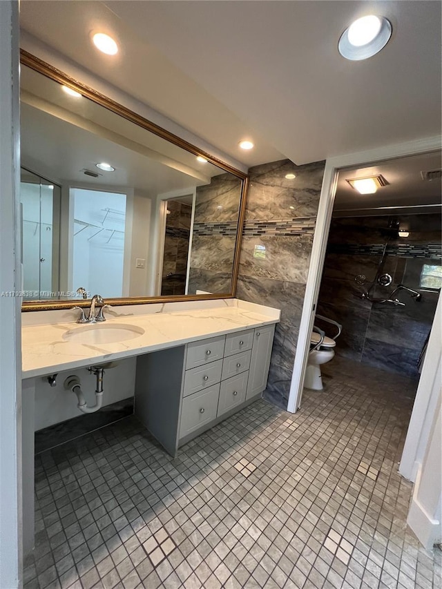 bathroom featuring tile walls, vanity, toilet, recessed lighting, and tiled shower
