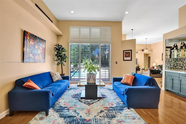 living area featuring recessed lighting, baseboards, and wood finished floors