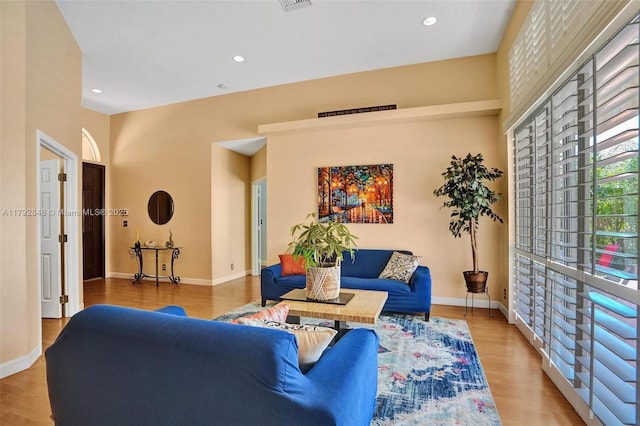 living room featuring recessed lighting, baseboards, visible vents, and wood finished floors