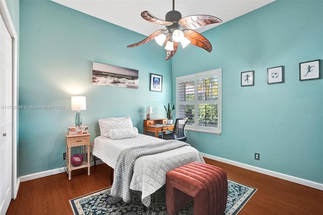 bedroom with baseboards, a ceiling fan, vaulted ceiling, and wood finished floors