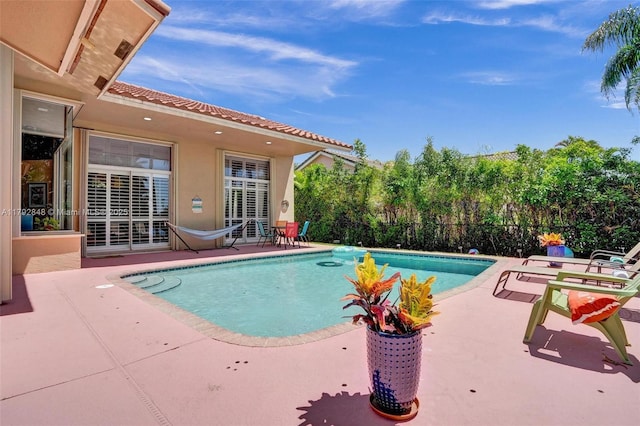 view of swimming pool featuring a fenced in pool, fence, and a patio area