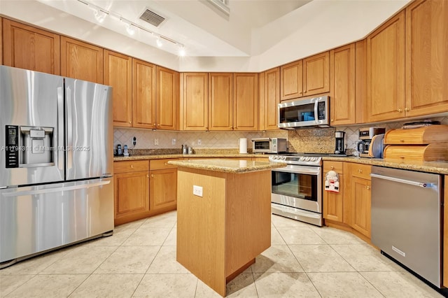 4123 W Lake Estates Dr, Davie, FL 33328 - kitchen featuring stainless steel appliances, a kitchen island, light tile patterned flooring, and tasteful backsplash