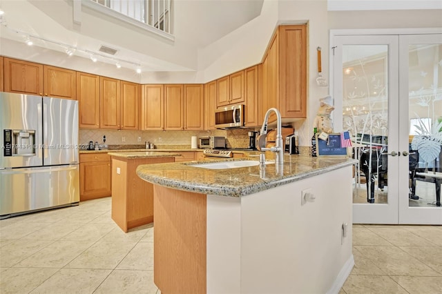 4123 W Lake Estates Dr, Davie, FL 33328 - kitchen with appliances with stainless steel finishes, french doors, light tile patterned floors, light stone countertops, and a center island