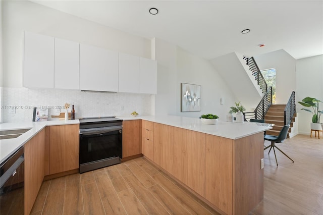 kitchen featuring electric range, modern cabinets, light wood-type flooring, dishwasher, and a peninsula