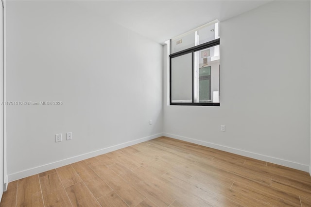 unfurnished room with baseboards and wood finished floors
