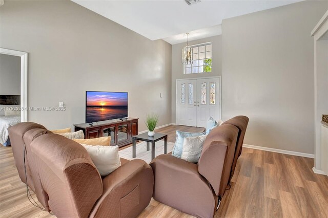 7649 Briar Cliff Cir, Lake Worth, FL 33467 - living room with a chandelier, light wood-style floors, a high ceiling, and baseboards