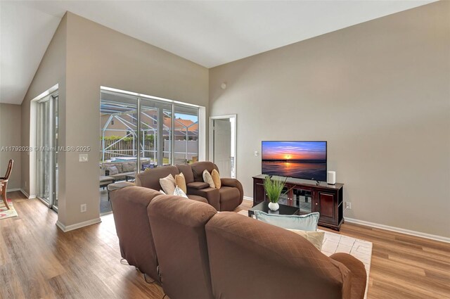 7649 Briar Cliff Cir, Lake Worth, FL 33467 - living room with wood finished floors, baseboards, and lofted ceiling