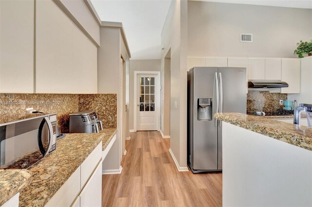7649 Briar Cliff Cir, Lake Worth, FL 33467 - kitchen with appliances with stainless steel finishes, under cabinet range hood, light wood-type flooring, and tasteful backsplash
