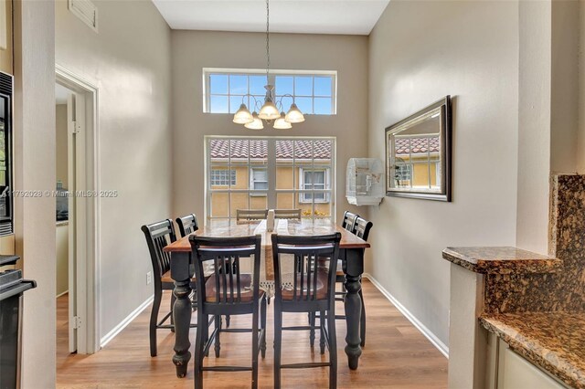 7649 Briar Cliff Cir, Lake Worth, FL 33467 - dining area featuring a chandelier, light wood-type flooring, and baseboards