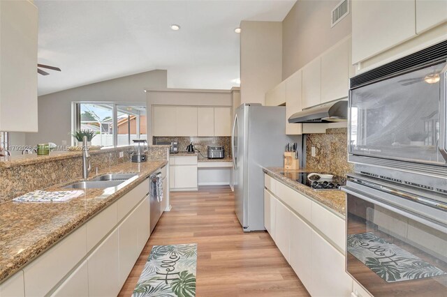 7649 Briar Cliff Cir, Lake Worth, FL 33467 - kitchen featuring a sink, ceiling fan, appliances with stainless steel finishes, under cabinet range hood, and lofted ceiling