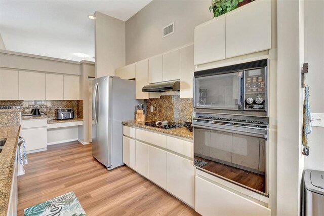 7649 Briar Cliff Cir, Lake Worth, FL 33467 - kitchen with black appliances, under cabinet range hood, backsplash, white cabinetry, and light wood-style flooring
