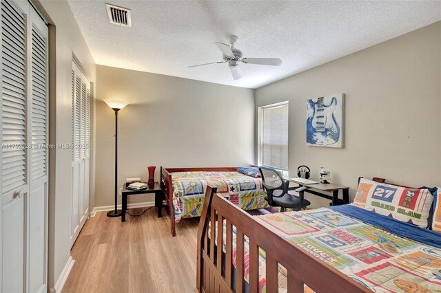7649 Briar Cliff Cir, Lake Worth, FL 33467 - bedroom with light wood-type flooring, ceiling fan, baseboards, and a textured ceiling