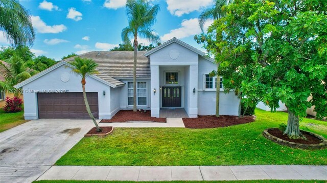 7649 Briar Cliff Cir, Lake Worth, FL 33467 - single story home with stucco siding, a garage, a front yard, and driveway