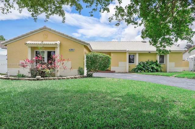 6340 NW 198th Ter, Hialeah, FL 33015 - single story home featuring a front lawn, aphalt driveway, stucco siding, and a tiled roof