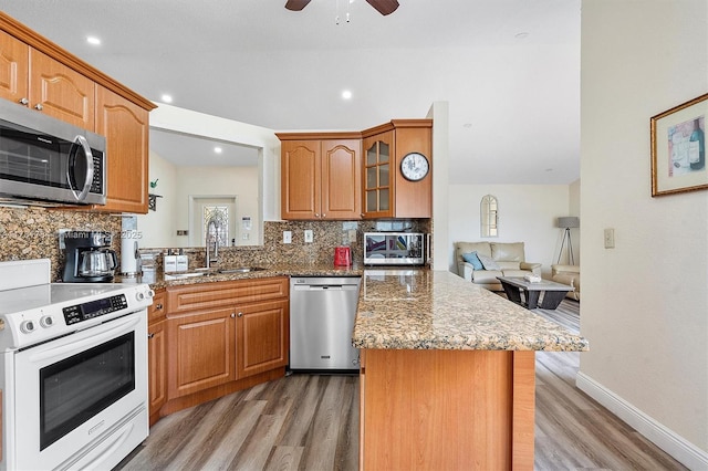 6340 NW 198th Ter, Hialeah, FL 33015 - kitchen with light wood-style floors, appliances with stainless steel finishes, tasteful backsplash, and a peninsula