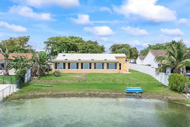 6340 NW 198th Ter, Hialeah, FL 33015 - rear view of house featuring a lawn, a water view, fence, and stucco siding