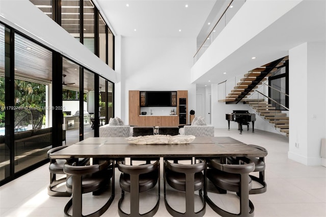 dining room with light tile patterned flooring, a high ceiling, french doors, recessed lighting, and stairway