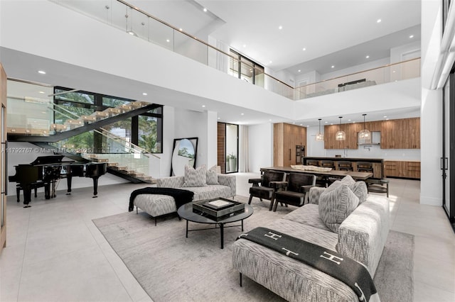 living room with light tile patterned floors, recessed lighting, a high ceiling, and stairs