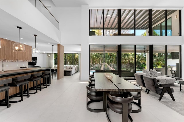 dining room with a towering ceiling and light tile patterned floors
