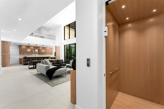 interior space with recessed lighting, elevator, and a towering ceiling