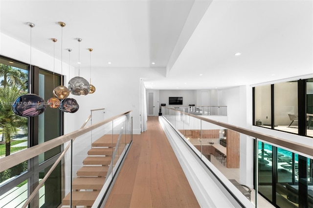 corridor featuring recessed lighting, an upstairs landing, and wood finished floors
