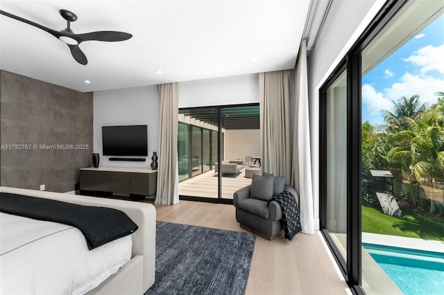 bedroom with access to outside, multiple windows, recessed lighting, and wood finished floors