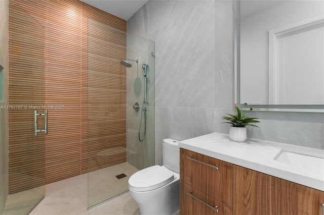 bathroom with vanity, tile walls, tile patterned flooring, and a tile shower
