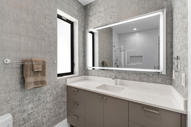 bathroom featuring vanity, walk in shower, and toilet