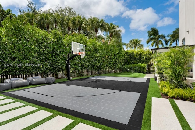 view of sport court with basketball hoop and fence