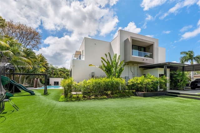 view of home's exterior with stucco siding, a yard, and playground community