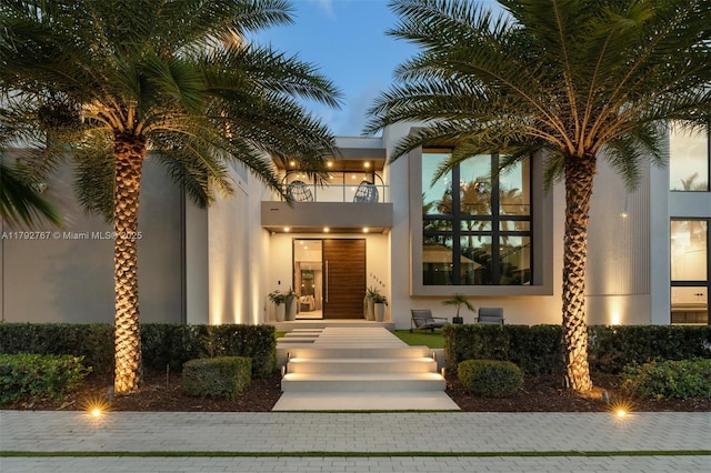 doorway to property featuring stucco siding and a balcony