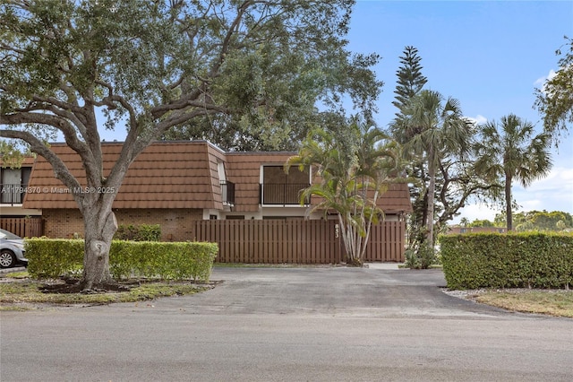 853 SW 118th Ter, Davie, FL 33325 - view of front of property featuring brick siding, mansard roof, and fence