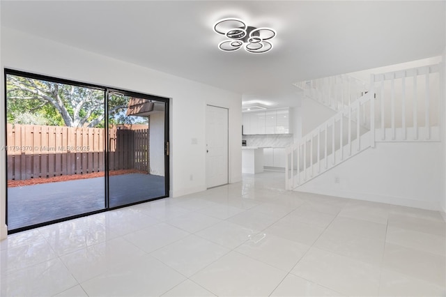 853 SW 118th Ter, Davie, FL 33325 - empty room featuring baseboards, light tile patterned floors, and stairway