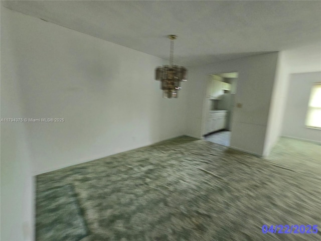 unfurnished dining area featuring carpet flooring and an inviting chandelier