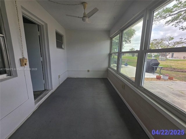 unfurnished sunroom featuring a ceiling fan