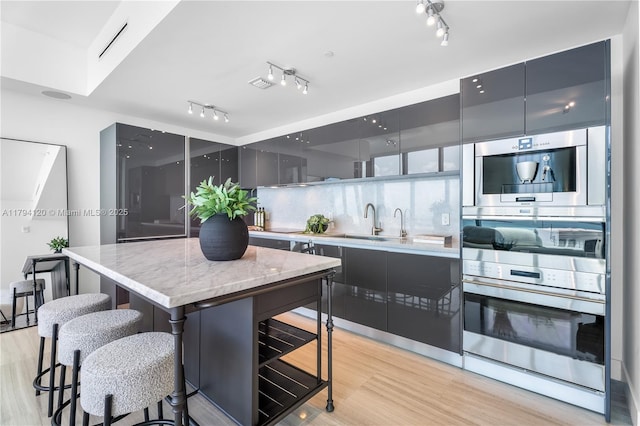 kitchen featuring a sink, modern cabinets, and light wood finished floors