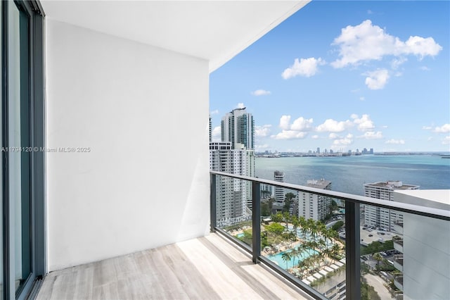 balcony featuring a water view and a city view