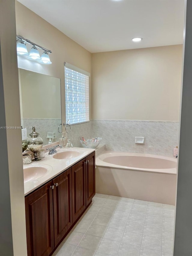 bathroom with double vanity, tile patterned flooring, a sink, and a bath