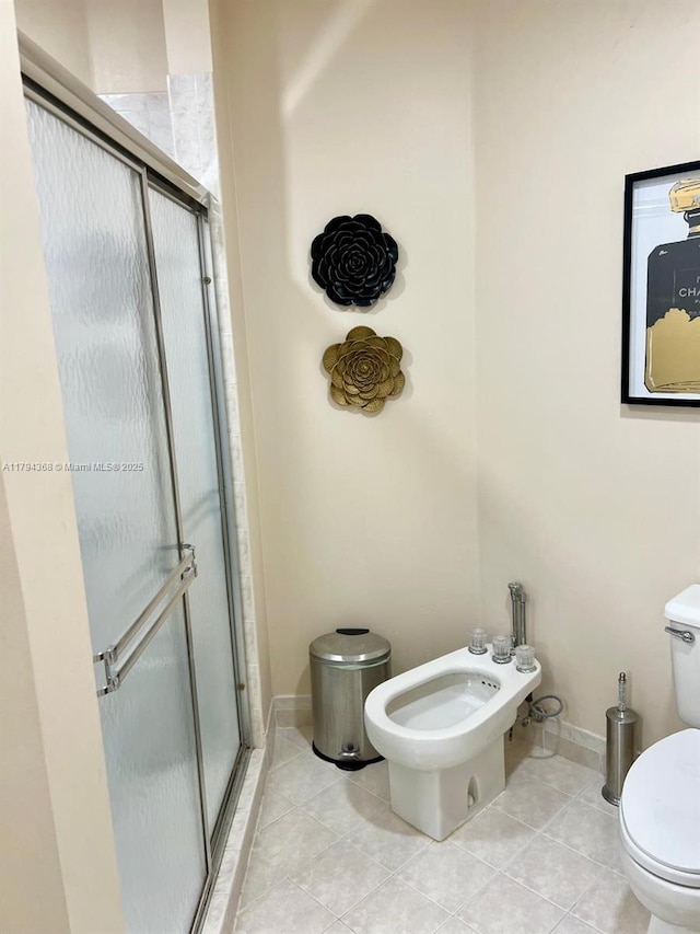 bathroom featuring toilet, baseboards, tile patterned floors, a bidet, and a stall shower