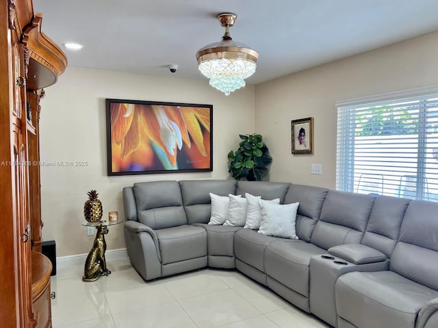living area with baseboards and an inviting chandelier