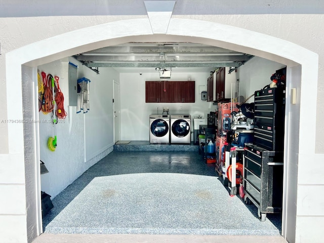 garage with washer and dryer, baseboards, a garage door opener, and electric panel