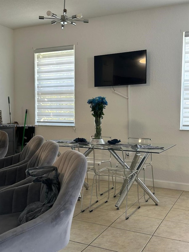 dining room featuring baseboards, light tile patterned floors, and a chandelier